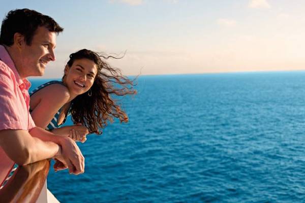 Ein glückliches Paar lächelt sich zu und verbringt eine romantische Zeit an Bord auf einem Carnival Cruise Line Schiff.